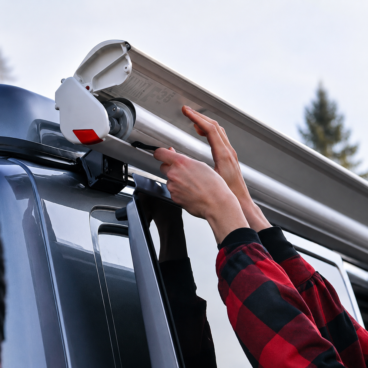 Fiamma F35 Pro awning being deployed on a van roof bar installation